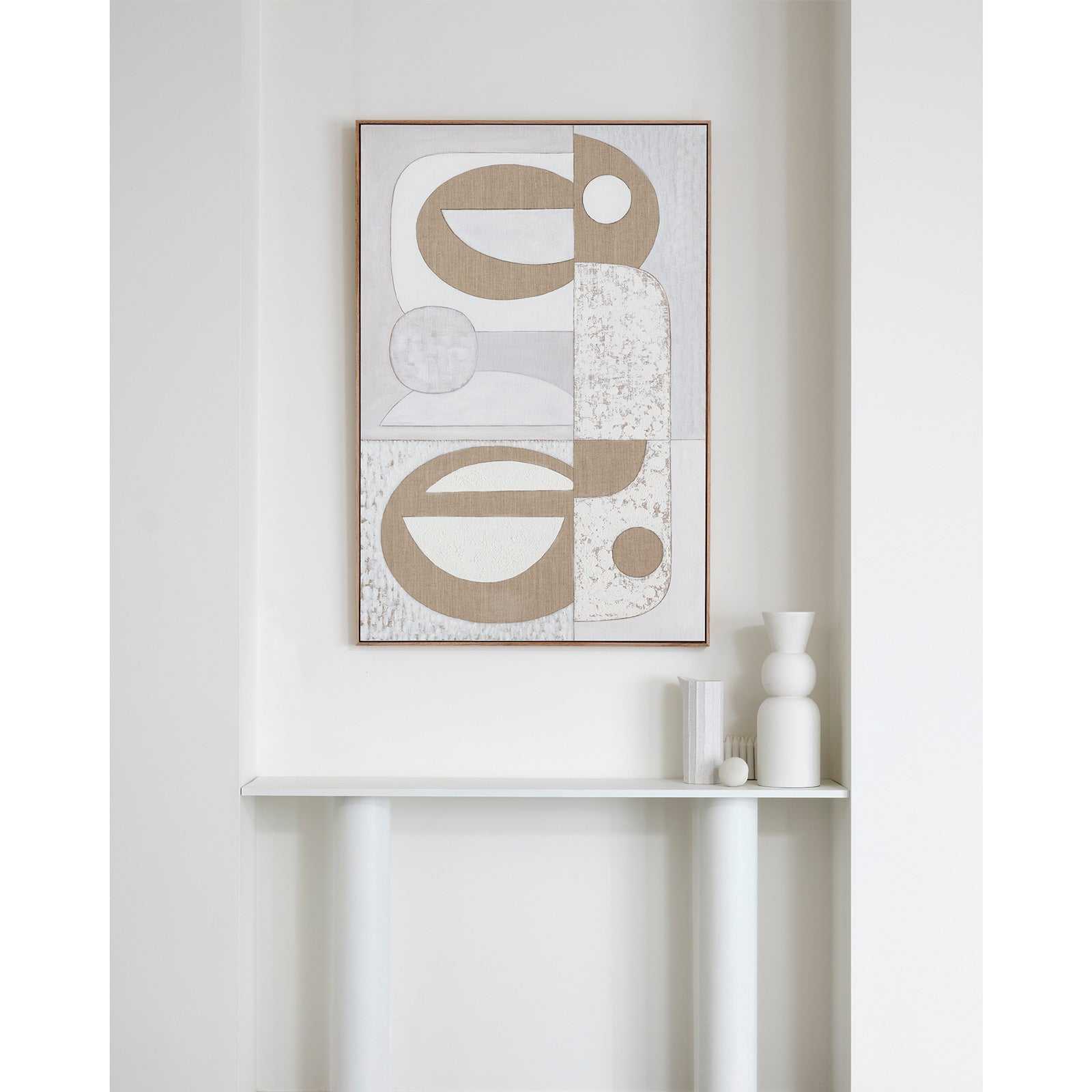 A framed Giclee print featuring geometric balanced design with earthy and neutral colors, displayed on a white wall above a white console table.
