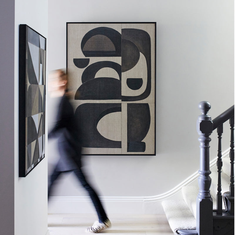 Abstract art piece in a hallway entrance with a person walking by